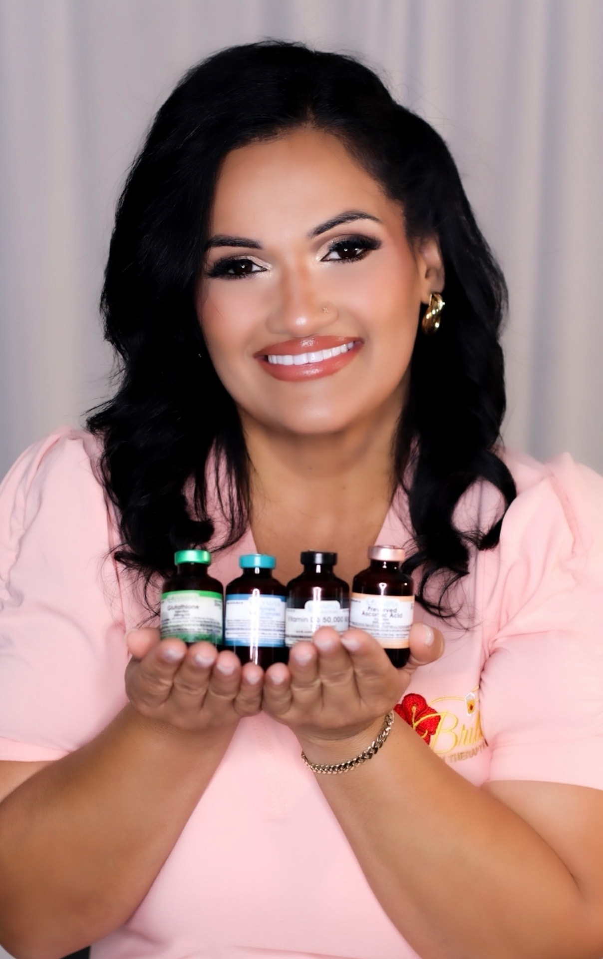 Brillaré founder in a blush medical top holding wellness vials